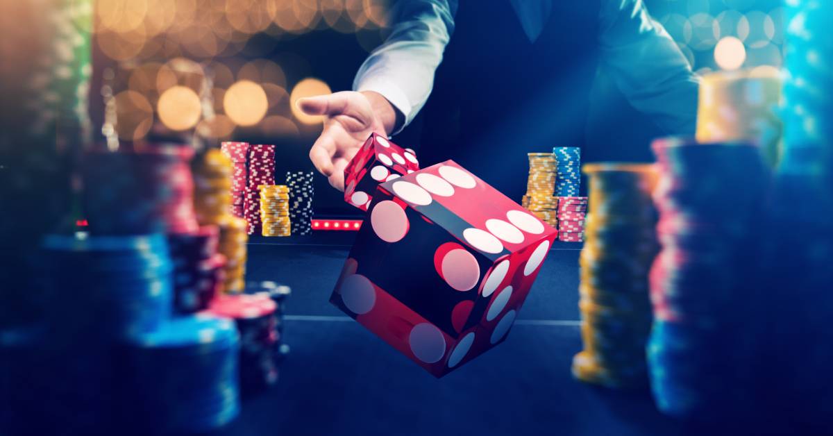 A point of view of a casino dealer throwing red casino dice at the viewer with stacks of gambling chips around.