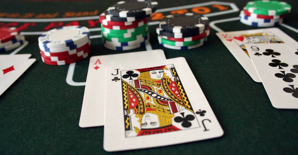 A blackjack table with pairs of cards, such as an Ace and a Jack or a King and a 9, with stacks of chips nearby.